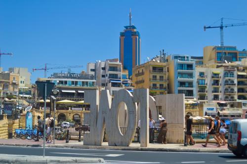 a large metal sign with people walking on a city street at Couple's Getaway in Is-Swieqi