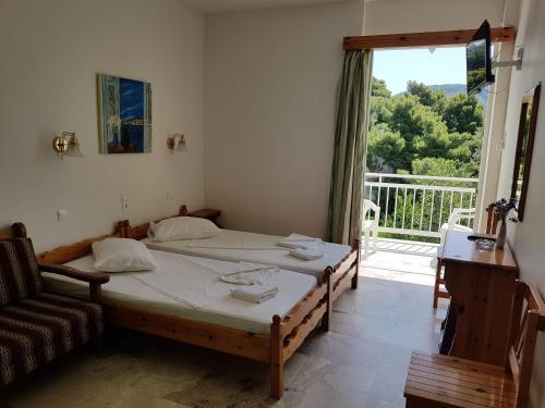 a bedroom with a bed and a couch and a window at Zontanos Studios & Apartments in Poros