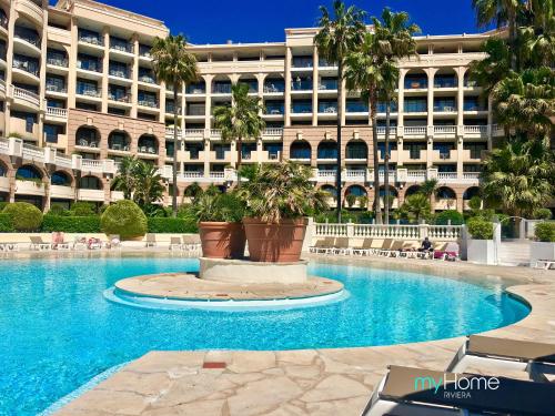 un hôtel avec un grand bâtiment en arrière-plan dans l'établissement MyHome Riviera - Cannes Sea View Apartment Rentals, à Cannes