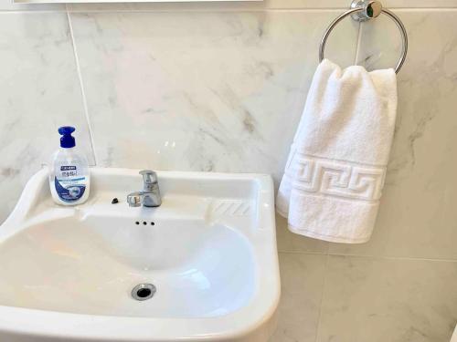 a bathroom sink with a bottle of soap and a towel at Split City Center Apartment in Split
