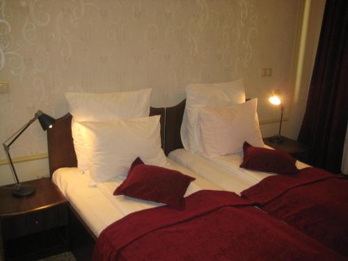 a bedroom with two beds with red and white pillows at Pension Casa Frieda in Sibiu