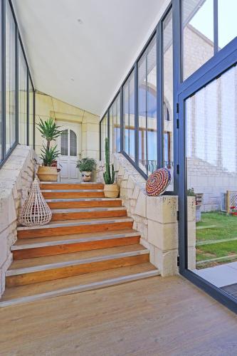 a staircase in a house with windows at L Esprit du Clain chambres d hôtes BandB de standing proches du Futuroscope Golf et Lac de St Cyr in Naintré