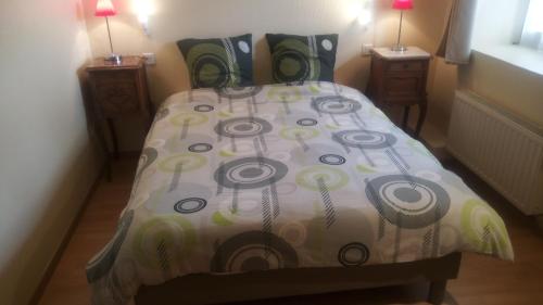 - une chambre avec un lit et une couette en fleurs dans l'établissement Gîte Yves, à Wihr-au-Val