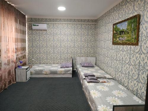 a room with two beds and a painting on the wall at Family Guest house - Friends-J in Nukus