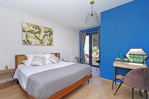 a bedroom with a bed and a desk with a computer at L Esprit du Clain chambres d hôtes BandB de standing proches du Futuroscope Golf et Lac de St Cyr in Naintré