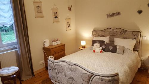 a bedroom with a bed with a teddy bear on it at Les Iris Chambres d’hôte in Niedermorschwihr