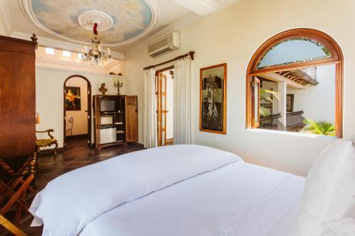 a bedroom with a white bed and a mirror at Hacienda San Angel in Puerto Vallarta
