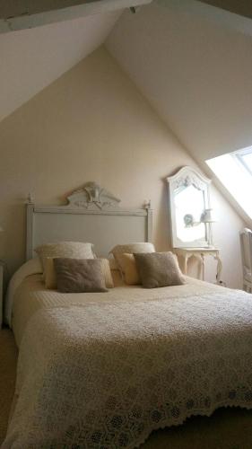 une chambre avec un grand lit dans un grenier dans l'établissement Gîte des petites Poules rousses 9 personnes Zoo Parc Beauval Saint Aignan et Châteaux de la Loire, à Choussy