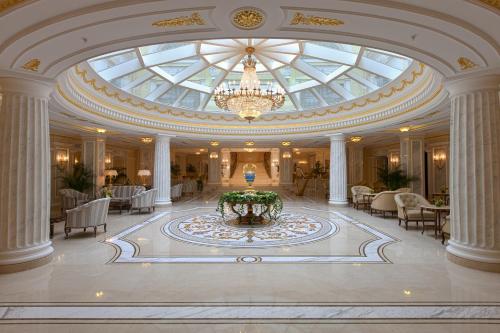a large lobby with a chandelier and a fountain in the middle at The State Hermitage Museum Official Hotel in Saint Petersburg