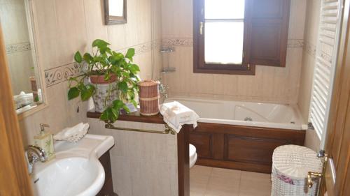 a bathroom with a sink and a toilet and a tub at El Rincón del Oteru in Llanes