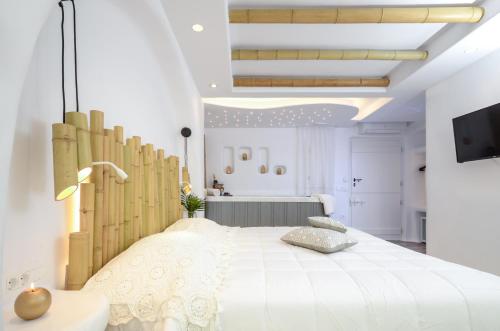 a bedroom with a large bed with a wooden headboard at Naxos Island Escape Suites in Plaka