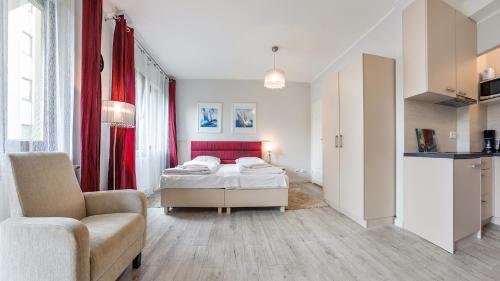 a bedroom with a bed and a couch and a chair at Sopot Residence - Sea Deluxe apartment B in Sopot