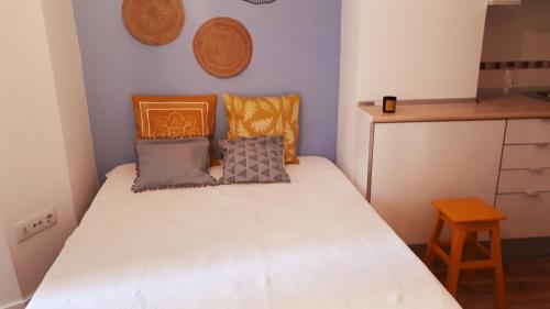 a small bedroom with a white bed with pillows at Studio S. Lourenço in Lisbon