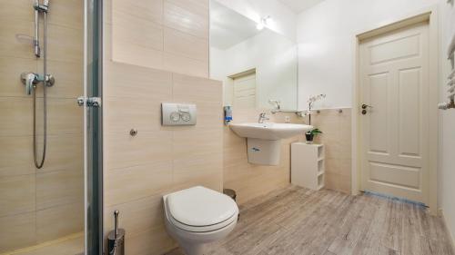 een badkamer met een toilet, een wastafel en een douche bij Sopot Residence - Sea Deluxe apartment A in Sopot