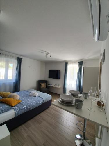 a bedroom with a bed and a table with wine glasses at Apartments Borghetto in Vinkuran