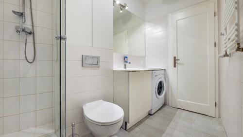 a white bathroom with a toilet and a shower at Sopot Residence - Sea Deluxe in Sopot