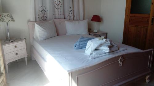 
a bed with a white comforter and pillows at Zacharoula Rooms in Manganítis
