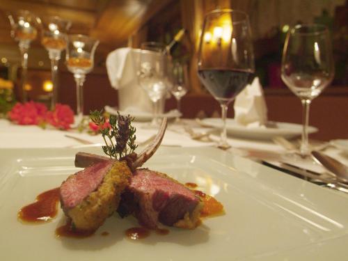 a piece of meat on a white plate on a table at Natur- und Aktivresort Reiterhof in Achenkirch