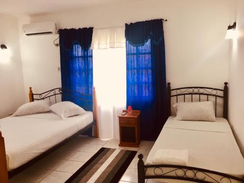 duas camas num quarto com cortinas azuis em Kevin's Court em Carnbee Village