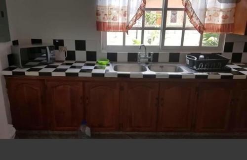 a kitchen with two sinks and a checkered counter top at Kevin's Court in Carnbee Village