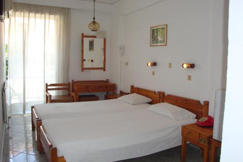 ein Schlafzimmer mit einem großen weißen Bett in einem Zimmer in der Unterkunft Karis Hotel in Kos-Stadt