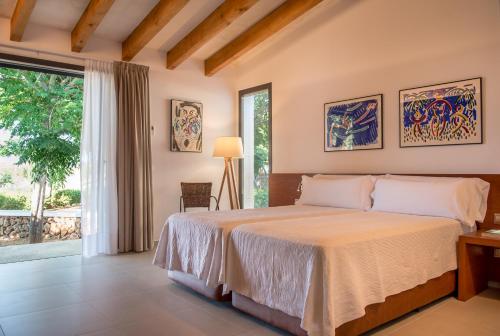 ein Schlafzimmer mit einem Bett und einem großen Fenster in der Unterkunft Hotel Rural Sant Joan de Binissaida in Es Castell