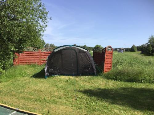 a tent sitting in the grass next to a fence at Västerdala Onwest in Äppelbo