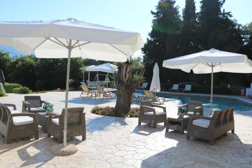 patio z leżakami i parasolami przy basenie w obiekcie Summer Wine Friendly Resort w mieście Ýpsos