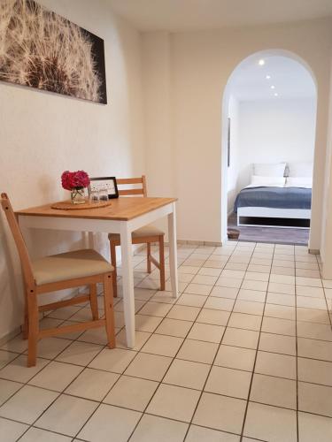 Zimmer mit einem Tisch, Stühlen und einem Bett in der Unterkunft Ferienappartement Jung in Kamp-Lintfort