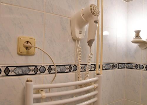a blow dryer in a bathroom next to a shower at Hotel Golf Ostrava Silherovice in Šilheřovice