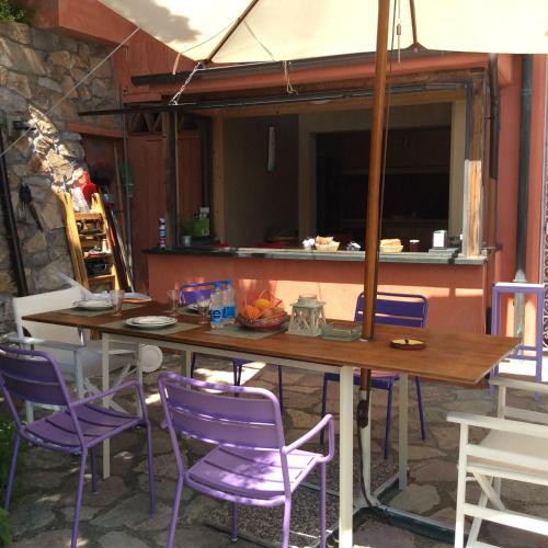 a table and some purple chairs on a patio at Cinqueterre Alla Chetichella in Lerici