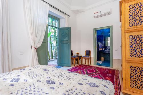 ein Schlafzimmer mit einem Bett und einem großen Fenster in der Unterkunft Riad Azahar in Marrakesch