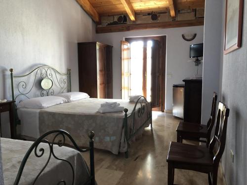 a bedroom with two beds and a chair and a window at Sa Crannaccia in Càbras