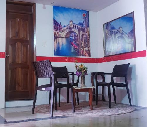un grupo de sillas en una habitación con una pintura en la pared en Hotel Allegria en Quito