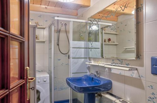 a bathroom with a blue sink and a shower at Casa Tinin in Loano