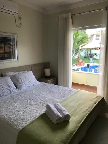 a bedroom with a bed with two towels on it at Casa Estância do Mar in Olivença