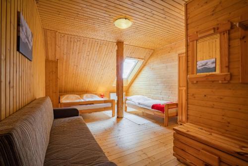 a room with two beds in a wooden cabin at Chata Magurka in Partizánska ľupča