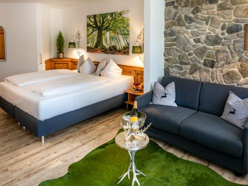 ein Hotelzimmer mit einem Bett und einem Sofa in der Unterkunft Mäser´s Allgäuherz in Wiggensbach