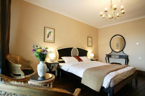 a bedroom with a bed and a vase of flowers at Arena Regia Hotel & Spa - Marina Regia Residence in Mamaia Nord