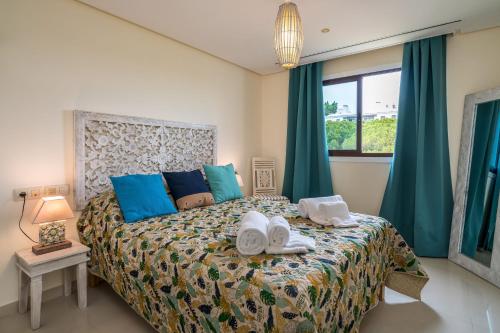 a bedroom with a bed with two towels on it at CAROB APARTMENT - BY MAYORAL (FALÉSIA BEACH) in Olhos de Água