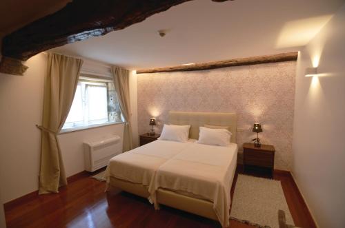 a bedroom with a white bed and a window at Quinta Vale do Homem in Amares