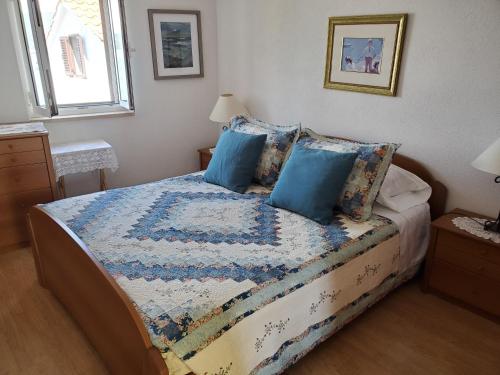 a bedroom with a bed with blue pillows at Valun Seaside Apartments in Valun