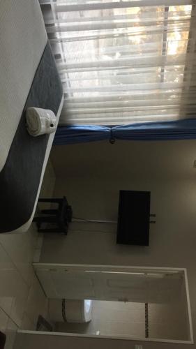 a bathroom with a toilet and a window with a paper at Villa Prince in Harare