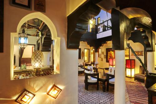 a hotel lobby with a mirror and a dining room at Dar Najat in Marrakech