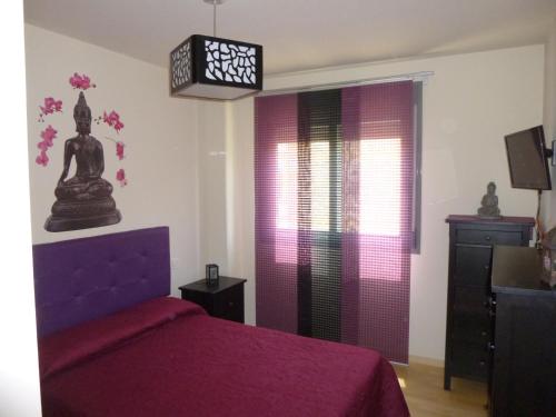 - une chambre avec un lit violet et une fenêtre dans l'établissement On the beach! Frente al Paseo Marítimo, Parking y Piscina, à Malaga