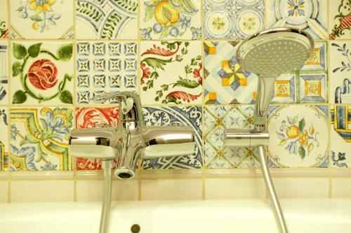 a bathroom sink with a chrome faucet and a tile wall at Arena Regia Hotel & Spa - Marina Regia Residence in Mamaia Nord