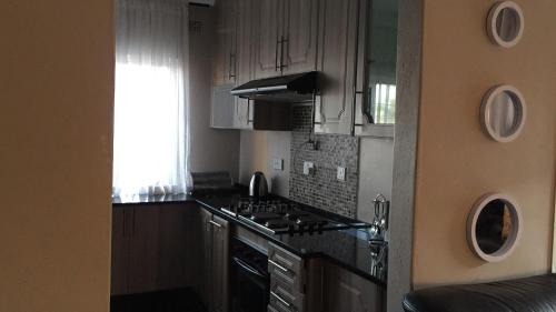 a kitchen with a stove top oven next to a window at Villa Prince in Harare