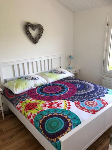 ein Bett mit einer bunten Decke in einem Schlafzimmer in der Unterkunft Les Moucherons in Avenches
