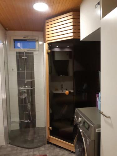 uma cozinha com um chuveiro e uma porta de vidro em Pieni moderni saunallinen kaksio keskustan lähellä em Pori