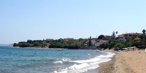 a beach with people sitting on the sand and the water at ThalaSEA Apartments in Chrani